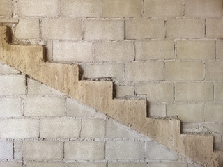 Staircase attached to the gray conctete blocks wall texture background.