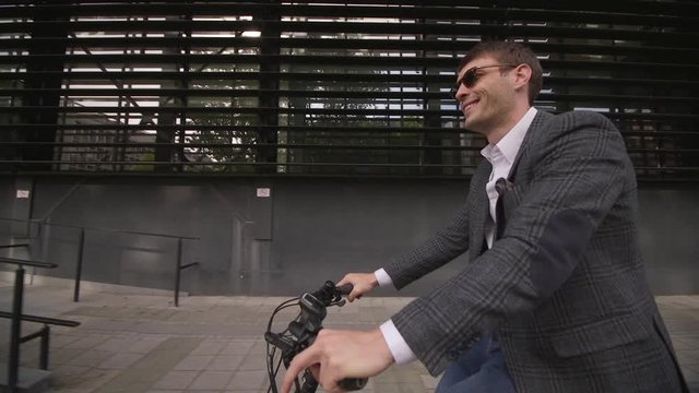 Handsome young businessman riding ebike in the city
