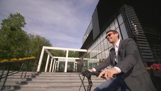 Handsome young businessman riding ebike in the city