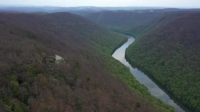 Aerial view trucking to the right and turning keeping the Coopers Rock overlook with panoramic views of the surrounding mountains and river.