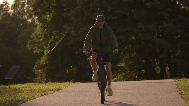 Handsome young man riding ebike in nature