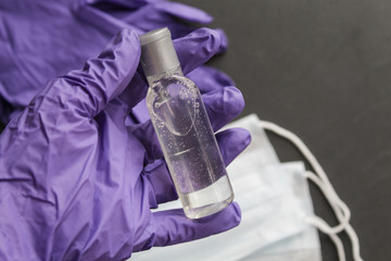 Disinfecting gel or antibacterial soap, disposable gloves and face mask for the prevention of coronavirus, on a gray background