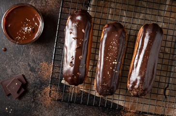 Chocolate glazed profiteroles on a dark background. handmade dessert. horizontal image. top view - obrazy, fototapety, plakaty