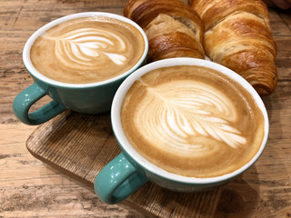 View of two cups of coffee and two croissants