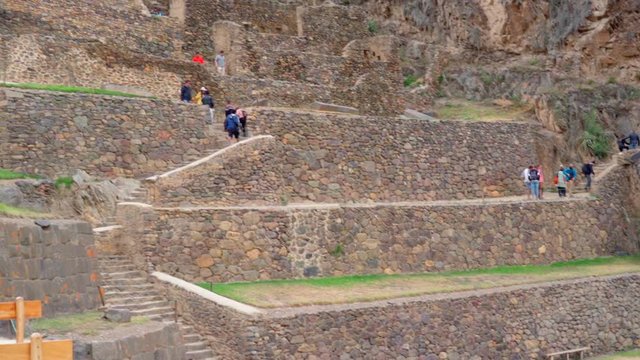Slow motion shot of tourists exploring at Machu Picchu, people walking at old ruins - Cusco, Peru