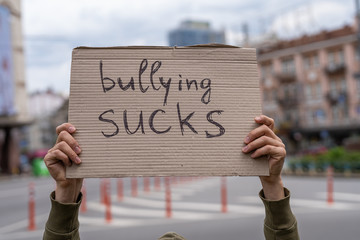 Stop bullying phrase poster demonstration. man holding sign with social message. parenting responsibility. social problems reflections banners. Man holding conceptual sign. Guy with sign inspiration.
