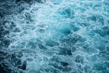 Fototapeta na wymiar The raging waters of the raging ocean. A cap of sea foam in a whirlpool.Abstract. Background.