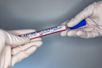 Naklejka premium Blurry image of a nurse hands while holding a test tube containing a patient’s sample that has tested positive for coronavirus