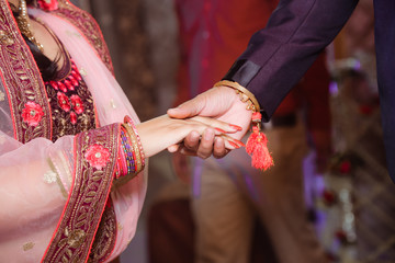 Fototapeta na wymiar Close up of Indian couple's hands at a wedding