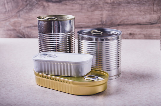 Set of various canned foods in tin cans on kitchen table, non-perishable, long shelf life food for survival in emergency conditions concept