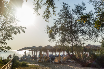 beach with beach umbrellas in sunset time