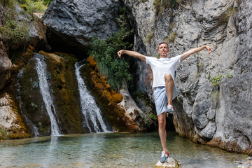 guy near a waterfall in Greece in the summer
