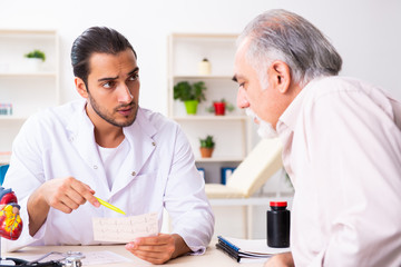 Old man visiting young male doctor cardiologist