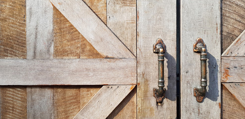 Grunge wooden door with stainless steel door handle and copy space on left. Wood background or wallpaper and close up object