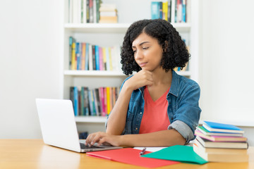 South american female student learning at computer in quarantine