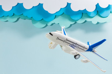 Plastic airplane, with cloudy sky made of paper