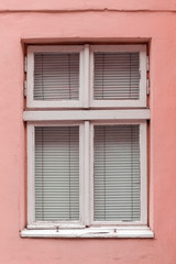 Fototapeta na wymiar Old vintage window in a white wooden frame on a pink wall.