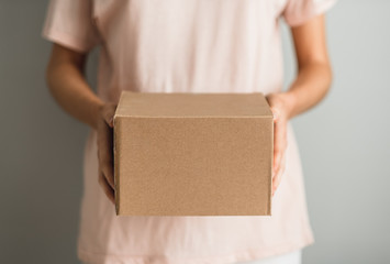 Woman holding a cardboard box, the parcel in hands. Delivery concept, mock up.