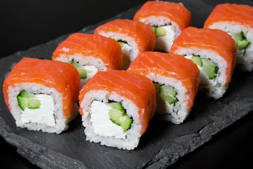 Philadelphia roll sushi with salmon on a dark background. Top view of sushi . Sushi food photo for menu.