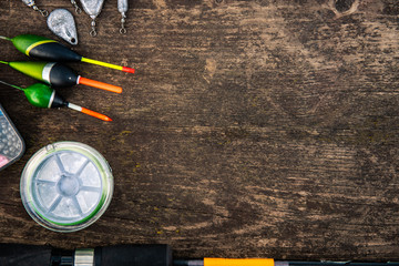 fishing equipment on a wooden table. Floats, sinkers, fishing line, hooks on a wooden background....