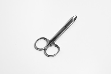 Small stainless steel scissors. Used for cutting nose hair and eyebrow decoration. Cosmetology equipment on a white background.High-resolution photo.