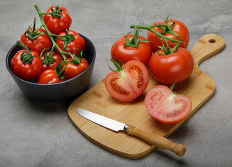 Fresh red variety of tomatoes on cocrete rustic table. Tomato vegetable concept