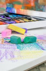  A close up of broken artists soft pastel chalk crayons on an art pad