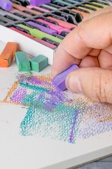 An artist using soft chalk pastel crayons for an abstract artwork