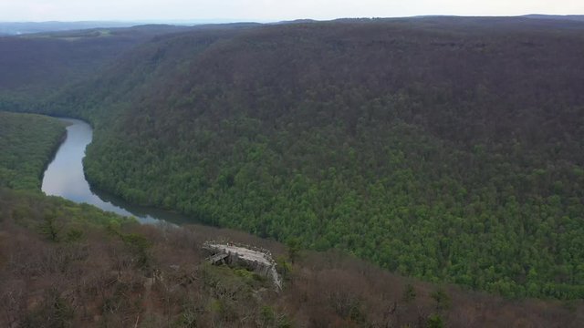 Aerial view pushing in over the Coopers Rock overlook with panoramic views of the surrounding mountains and river.
