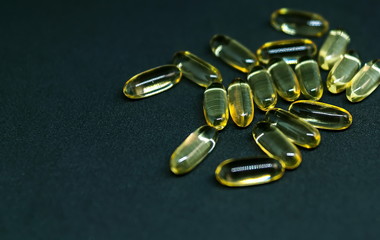 Fish Oil Capsules and Pills Bottle on dark background. Omega-3. Selective focus