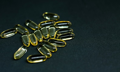 Fish Oil Capsules and Pills Bottle on dark background. Omega-3. Selective focus