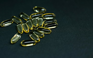 Fish Oil Capsules and Pills Bottle on dark background. Omega-3. Selective focus