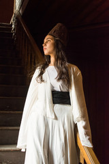 Portrait for a Sufi whirling woman dancer wearing white dress (Turkish/Semazen) performing art of Sama or physically active meditation of Sufism, and during spiritual dancing performance at Egypt