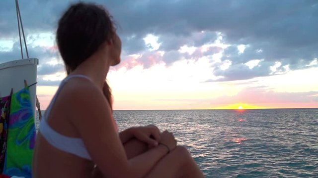 Slow motion of female tourist enjoying on boat in sea against sky, closeup of young woman singing during sunset - Montego Bay, Jamaica