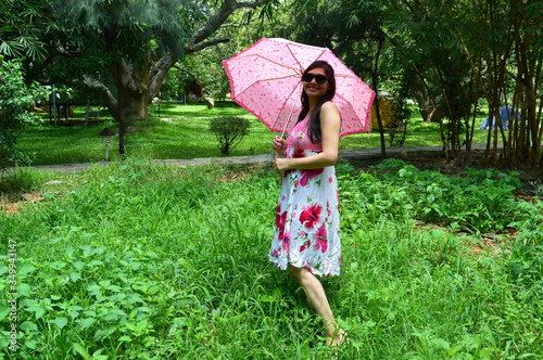 Beautiful Indian Woman In One Piece Gown In Park Garden With Umbrella Sunglasses Outdoor Photoshoot Potrait Pose Autumn Wall Mural Autu Hitesh