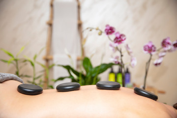 Health spa relaxing stone therapy with hot volcanic stones on back