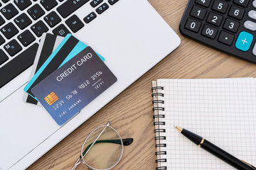 Computer laptop, credit cards, calculater, notbook pen and glasses on the desk, account and saving concept..