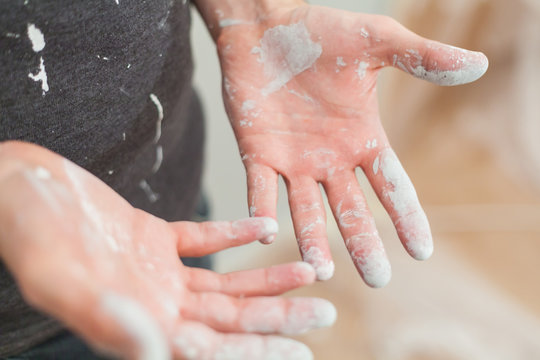 Craftsman with white paint particle at hands and clothes after painting work renovation dirty work training teaching profession do it yourself