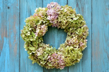 Delightful wreath of hydrangeas on old blue wooden background close-up