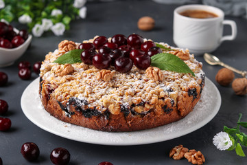 Homemade cherry pie with shtreisel on white plate on a dark concrete background, closeup, horizontal format, Closeup