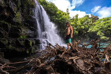 Athlete traveler enjoys the view of the waterfall with clear water