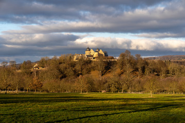 European landscape with fall colors and castle on a hill with clouds