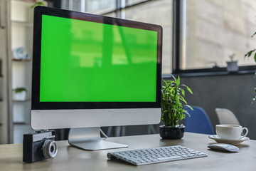 Computer desktop with mock-up green screen white background in office and Lovely plant in black pot