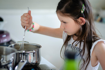 Kid school mixing a home made pudding on the stove