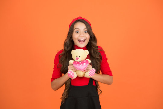 Got her surprise present. Happy girl hold teddy bear brown background. Present for Valentines day. Cuddly toy present. Gift or present shop. Toy store. Holiday greetings. Declaration of love