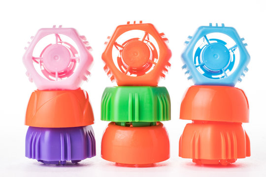Three stacks of colored plastic bottle caps look like little men.