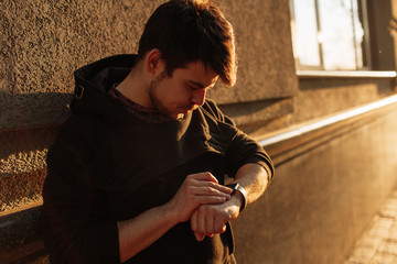 Man looking at his smartwatch in the city. Business concept.
