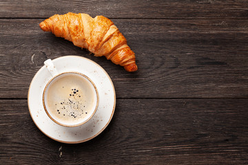 Coffee and croissants on wooden table