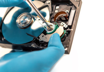 the disassembled hard disk is repaired using tools and rubber gloves to ensure cleanliness
