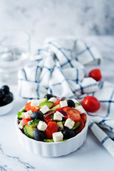 Greek Salad with ingredients in a white bowl